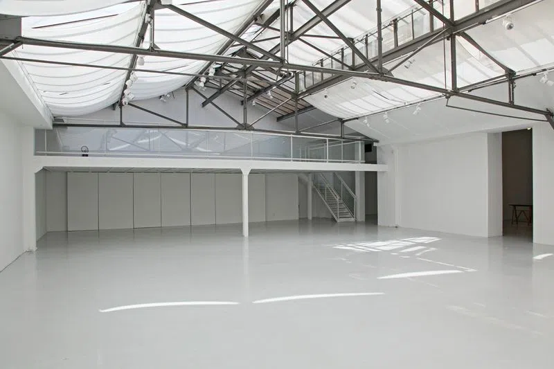 Caché au fond d'une cour pavée typiquement parisienne, cette ancienne imprimerie est aujourd'hui transformé en loft. Très spacieux (environ 350m2), mais aussi lumineux grâce à son grand plafond en verrière, c'est un espace rempli de puits de lumière. Il est également pourvu d'une mezzanine qui peut servir de bureau ou même d'espace d'exposition supplémentaire. C'est le showroom idéal pour les amateurs d'ambiances industrielles/modernes. Loft S