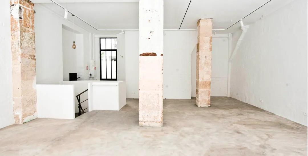 Des murs blanchis à la chaux donnent à cette galerie des airs de maison grecque ou toscane. Au coeur du 11e arrondissement de Paris, quartier vivant de la mode, cet espace de 120m2 (70 RDC, 50 sous-sol) conviendra tout à fait pour un showroom. Il fait profiter d'une belle vitrine sur rue dans une ambiance chaleureuse et industrielle. Très lumineux, tout équipé, ce lieu offre une très belle luminosité naturelle, complétée par des rails de spots en plafond. Un endroit avec une identité facilement personnalisable. Galerie Grecque